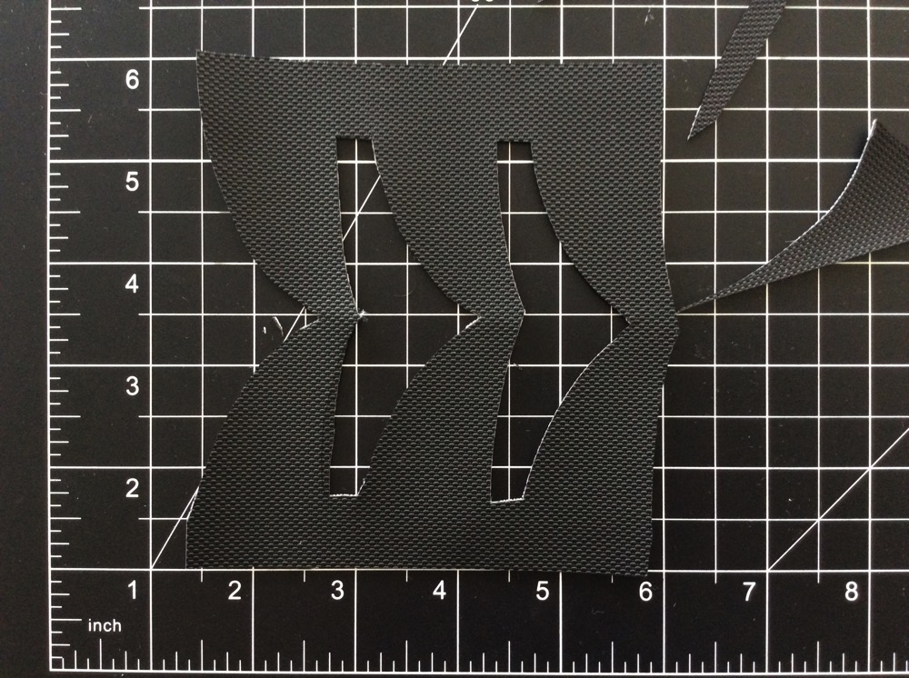Fabric cut to size, with the four negative-space pieces cut out of it.