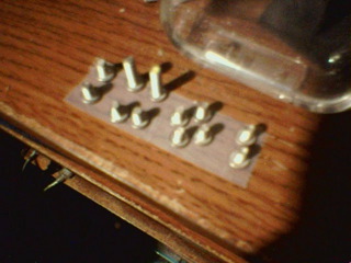 All the applicable screws removed and stuck by their heads to a strip of Scotch tape.